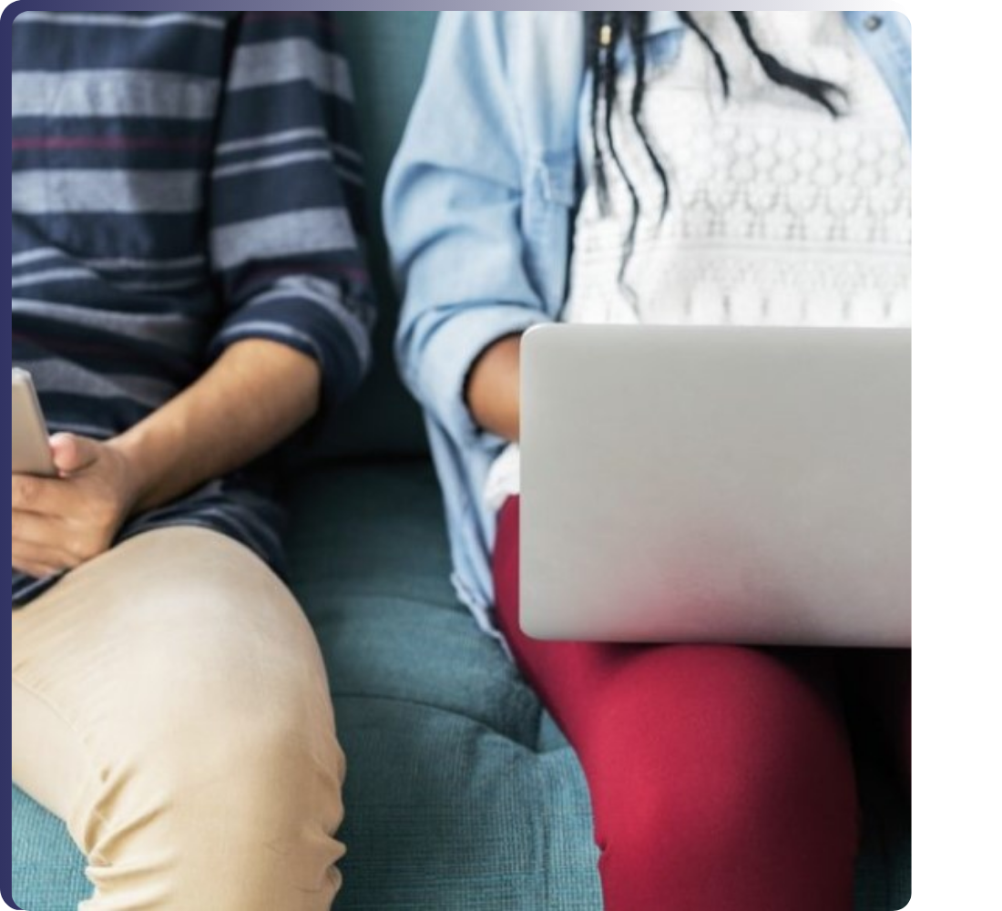 Two people sitting side by side using mobile devices